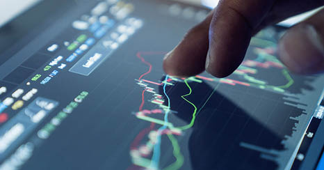Market Analyze with Digital Monitor focus on tip of finger.